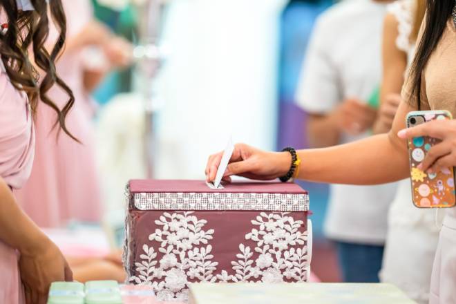 Ospite del matrimonio che mette una busta in un'urna