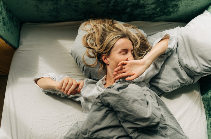 Una donna sbadiglia nel suo letto