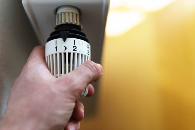 Uomo che regola il termostato di un radiatore