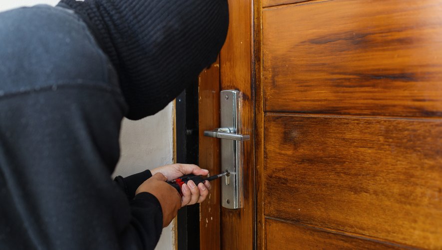 Un ladro forza la serratura di una casa