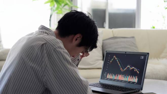 Uomo depresso che vede cadere i prezzi delle azioni
