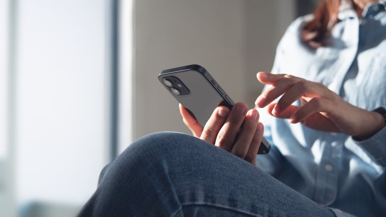 Una donna che legge un SMS ricevuto sul suo smartphone