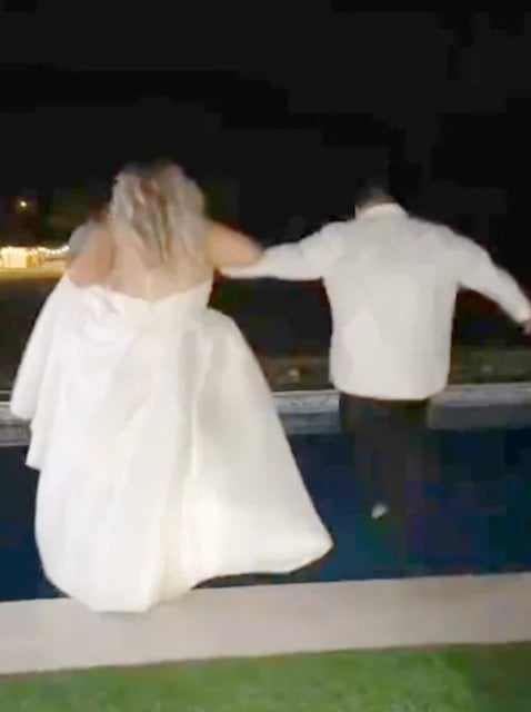 La sposa e lo sposo saltano in piscina