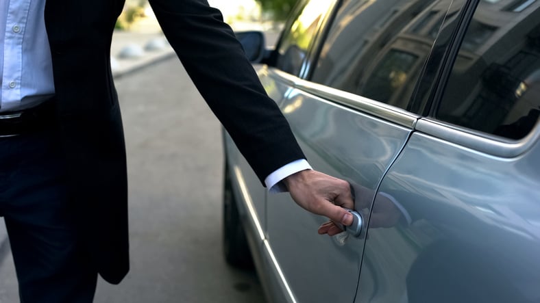 Un tassista apre la portiera dell'auto