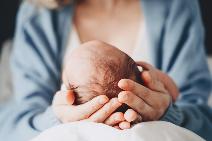 Un neonato nelle mani di sua madre
