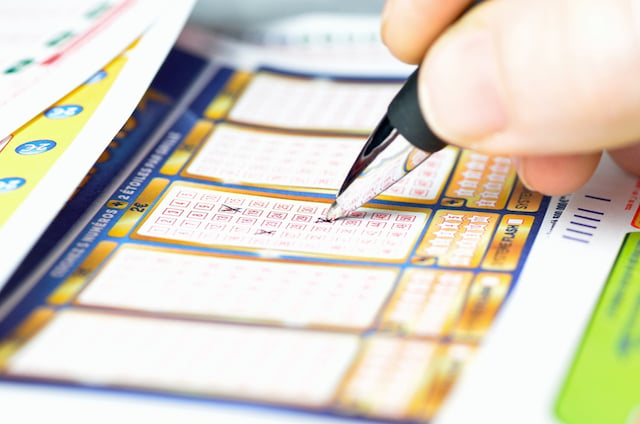 Una persona che compila una griglia della lotteria