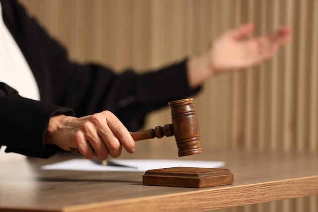 Un giudice che colpisce il martelletto su un tavolo di legno