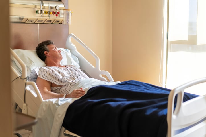 Un uomo su un letto d'ospedale