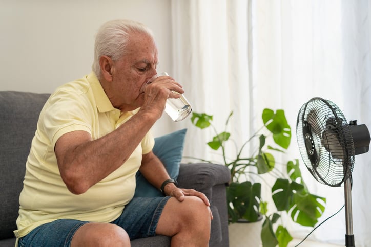Un uomo anziano beve acqua