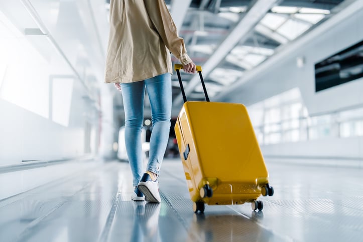 Una donna cammina con la sua valigia