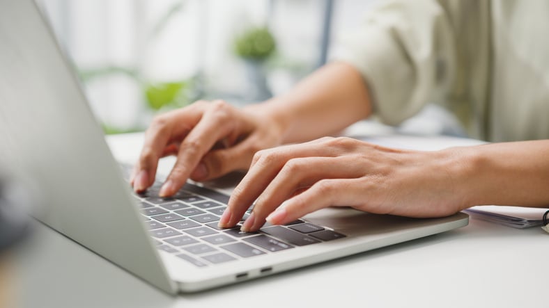 Una donna digita sulla tastiera di un computer