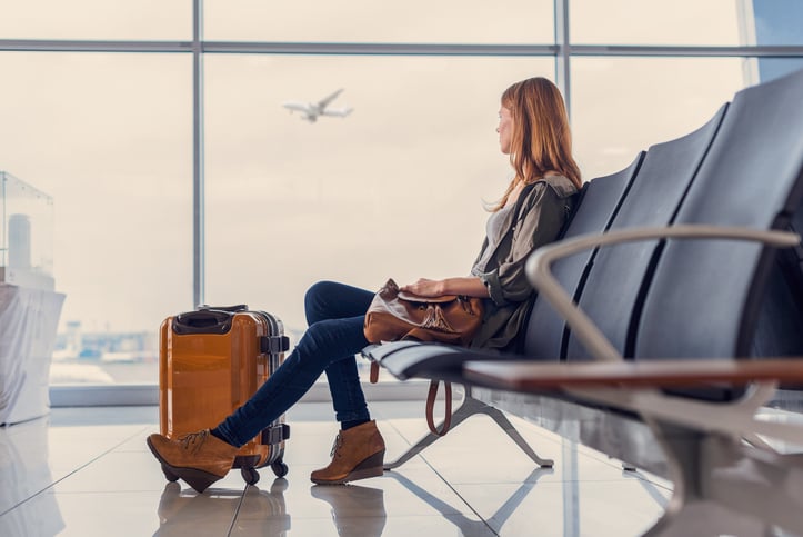 Una donna aspetta in un aeroporto