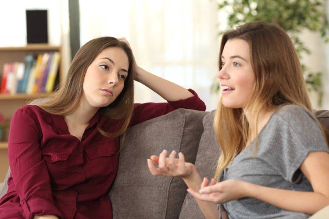 Ragazza annoiata che ascolta la sua amica parlare