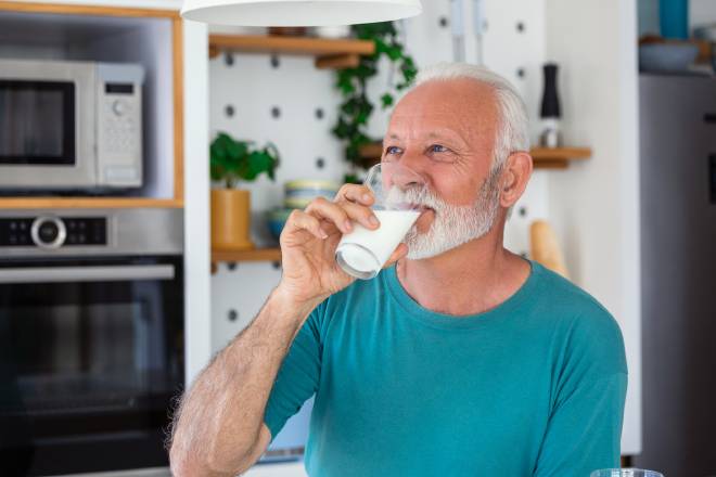 Uomo anziano che beve latte