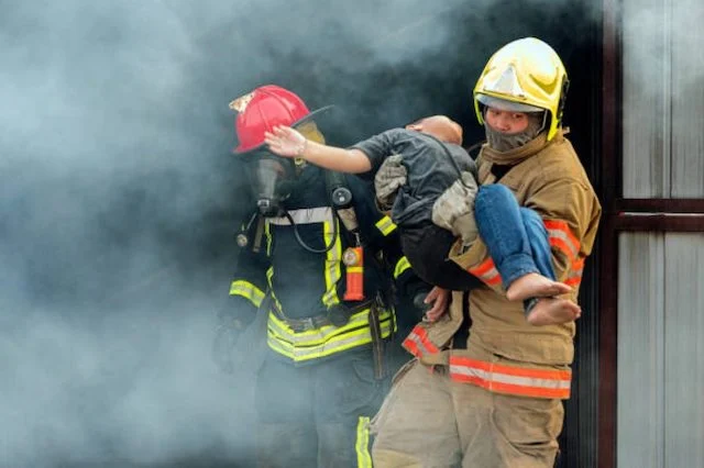 Un pompiere con in braccio un bambino