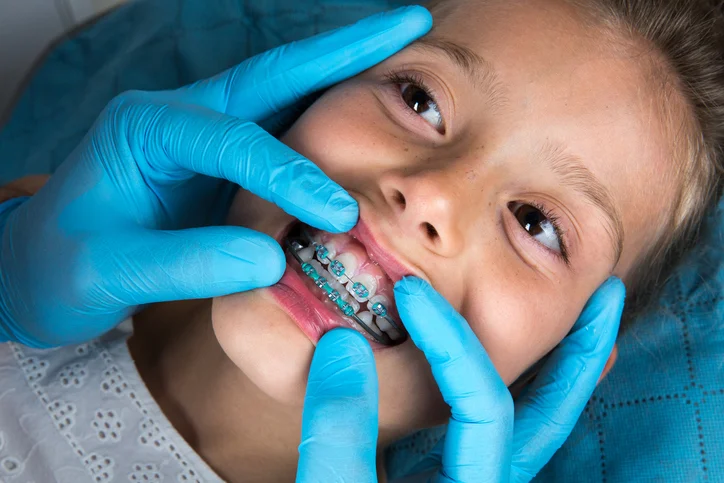 Ragazza giovane, indossando bretelle, visitando il dentista