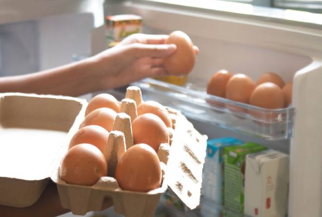 Persona che mette le uova nel frigorifero