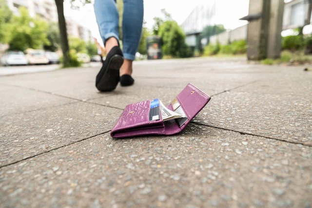 Una donna che ha lasciato cadere il portafoglio per strada