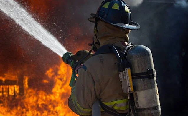 Un pompiere spegne un incendio