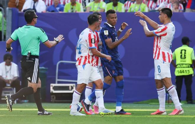 Kylian Mbappé circondato da giocatori paraguaiani durante la partita Paraguay-Francia