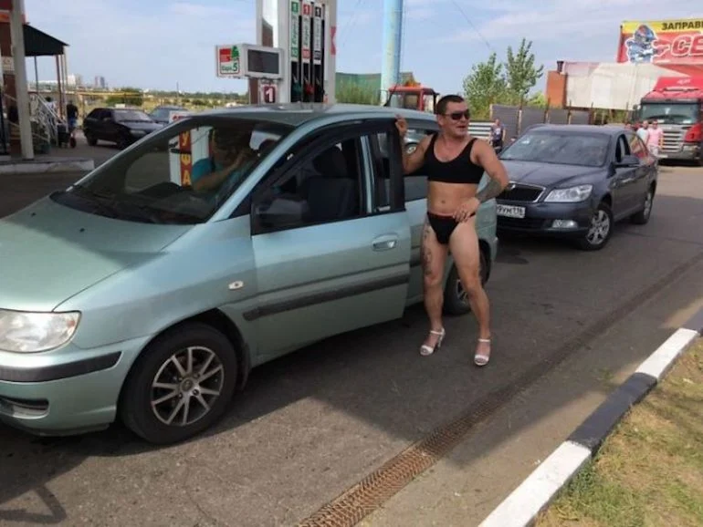 Uomo in bikini in una stazione di servizio in Russia