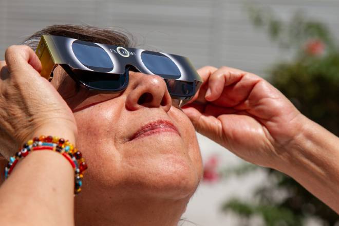 Donna anziana che guarda l'eclissi solare con un paio di occhiali