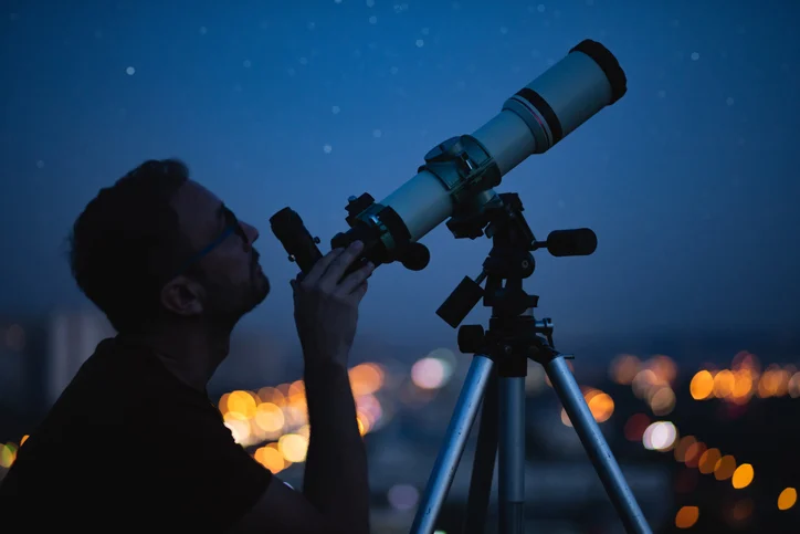 Un uomo usa un telescopio