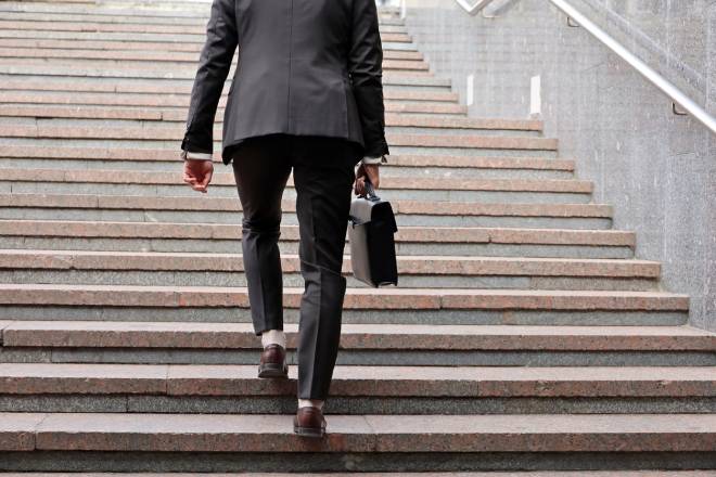 Uomo d'affari con valigetta salendo le scale