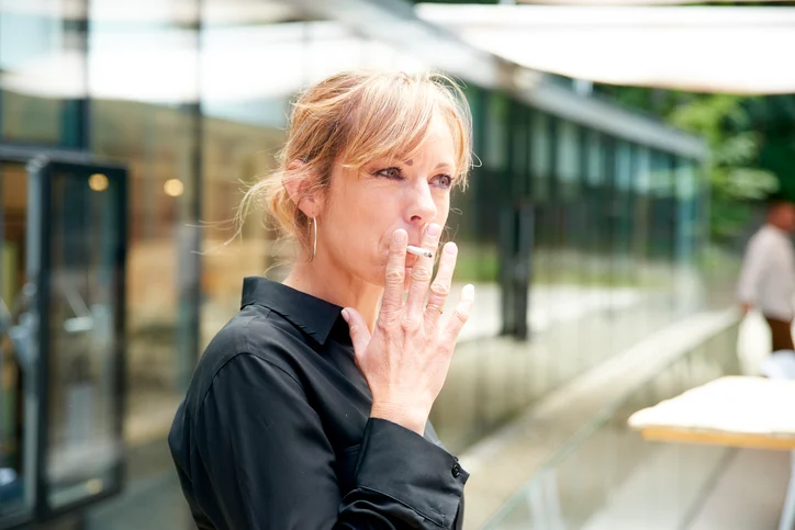 Una donna fuma una sigaretta