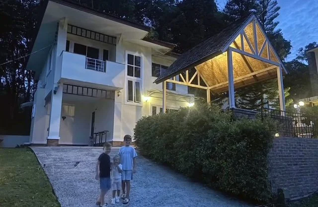 I tre figli della coppia davanti alla loro villa in Thailandia