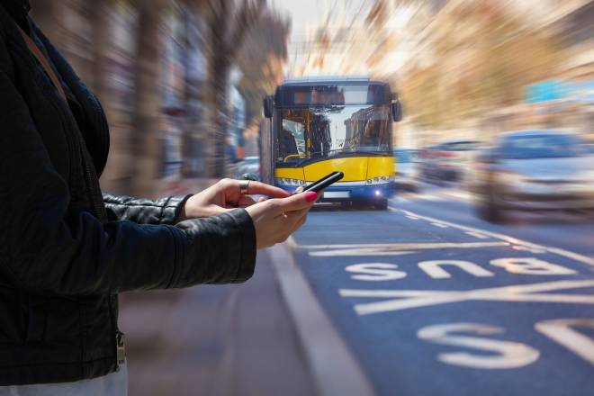 Pedone con il telefono in mano mentre un autobus si avvicina