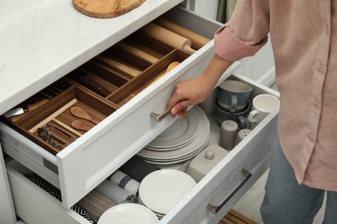 Donna che apre i cassetti della cucina