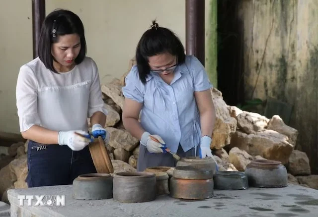 Esperti del Museo di Ninh Binh esaminano i vasi