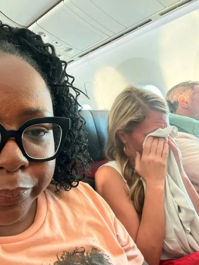 La blogger Tomiko Harvey su un aereo accanto al suo vicino che piange